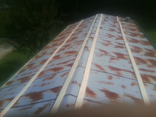 Rusted metal roof panels with new wood purlins before replacement — Storm Damage Roof Repair in Columbia Cross Roads by Roofing Brothers