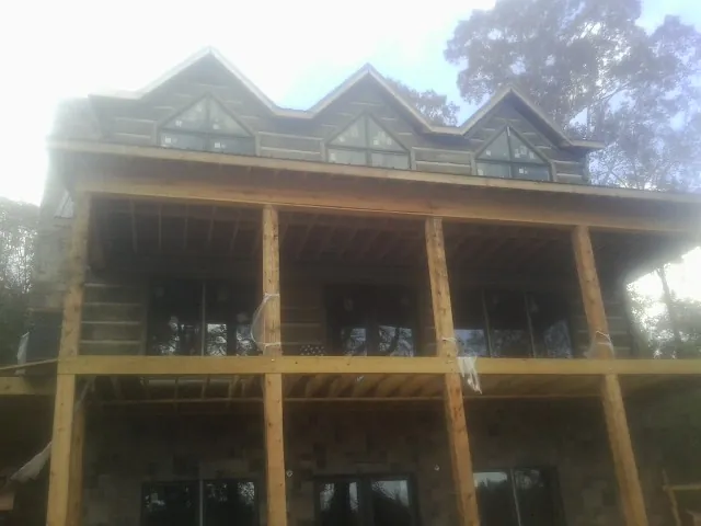 Dormers and porch framing on a large log home under construction — Roof Coating work by our crew in Columbia Cross Roads