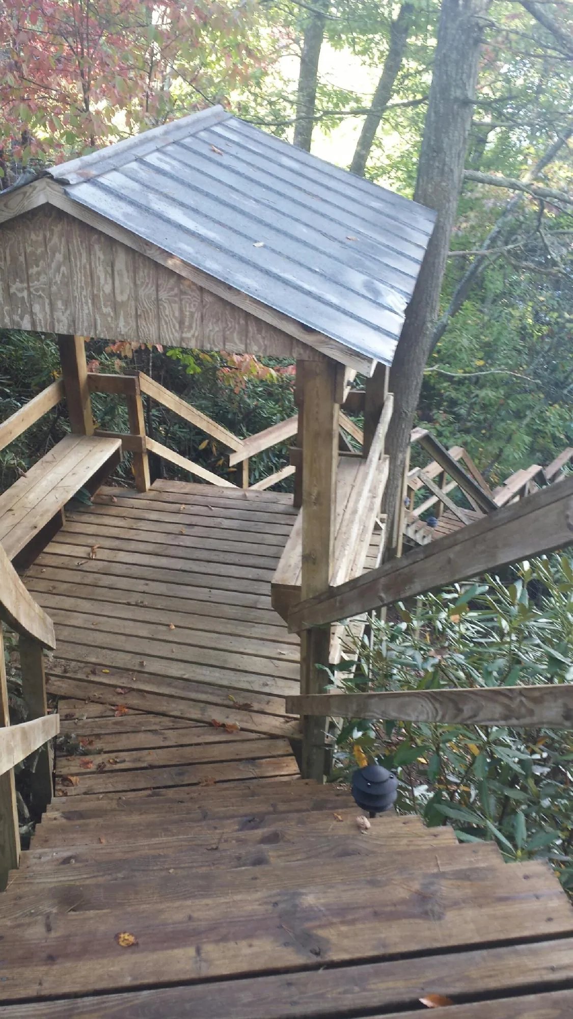 Metal roofed shelter over wooden steps on a wooded walkway — Skylight Repair & Installation work by our crew in Columbia Cross Roads