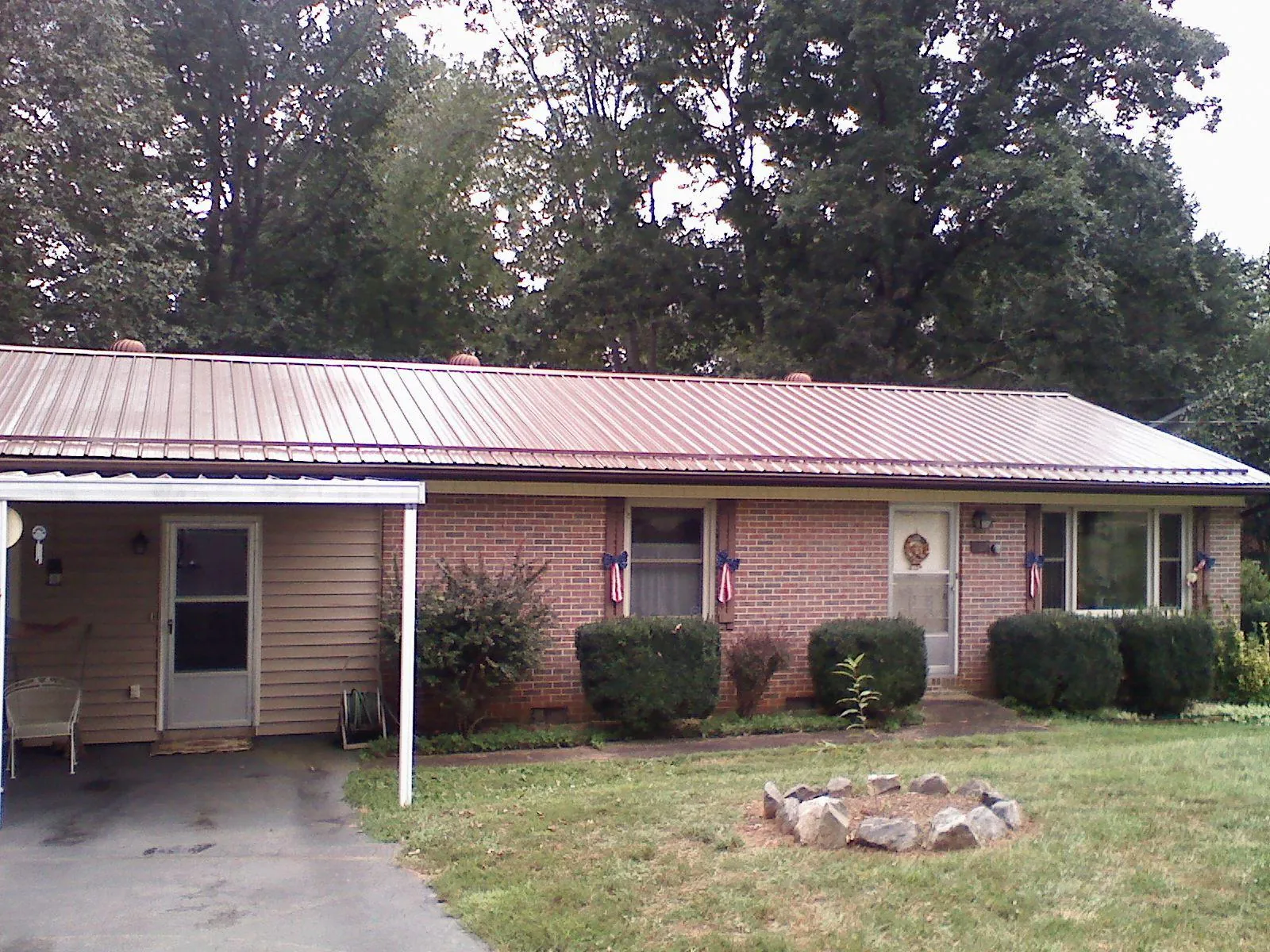 Bronze metal roof and carport on a brick ranch home — Roof Repair work by our crew in Columbia Cross Roads